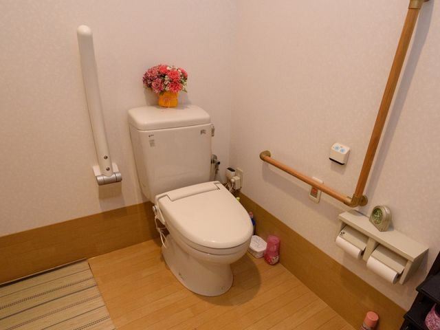 バリアフリー対応のトイレ トイレ 安全に配慮された手すり完備のトイレです。清潔感があり、花を飾ることで温かみを感じさせる空間となっています。