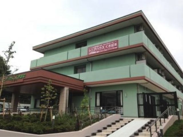 緑色の建物エントランス 外観 落ち着いた色合いの外観が印象的な、働きやすい環境が整っております。訪れる方々を暖かく迎えるエントランスが特徴です。