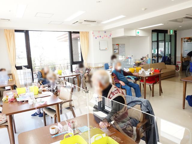 居心地の良い共有スペース 共有スペース 明るく広々とした食堂で、利用者の方々が穏やかに過ごされています。共有スペースでは、お食事や様々な活動を楽しめるよう配慮されています。
