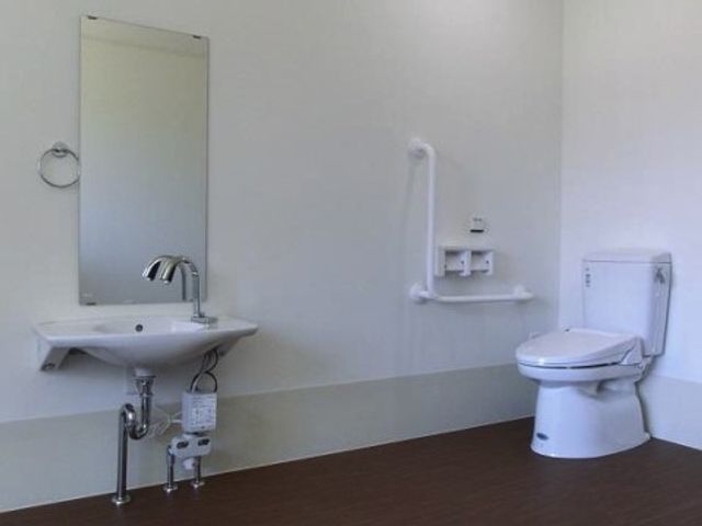 清潔なトイレと洗面台 トイレ 手すりが備え付けられた清潔なトイレで、安全に快適な利用ができるよう配慮されています。