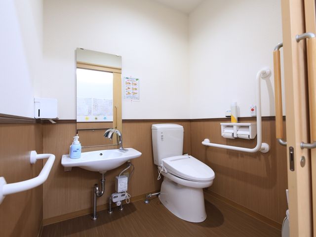バリアフリー設計の洗面台とトイレ トイレ 手すり付きで安全を考慮した清潔なトイレです。快適にご利用いただけるよう、利便性に配慮して設計されています。