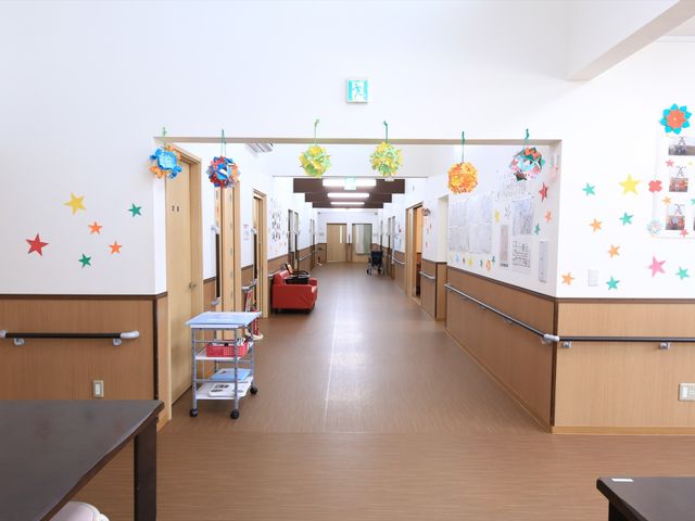 明るく清潔な廊下 通路 ゆったりとした広さのある廊下は、壁に飾られた装飾が心地よい雰囲気を醸し出しています。手すりが完備されており、安全に配慮された設計となっています。