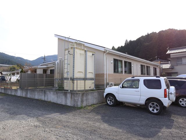 施設のシンプルな外観 駐車スペース 清潔感のあふれる建物の外観です。自然に囲まれ、静かな環境での就業をご希望の方に適しています。