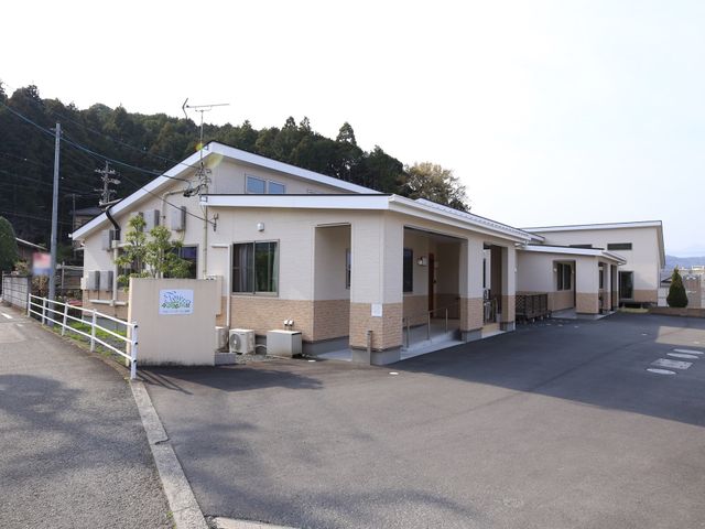 明るい外観の施設 外観 広々とした敷地に構える、落ち着いた色合いの建物です。周囲には緑も豊かで、静かな環境が広がっています。