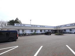 白い壁の建物と駐車場