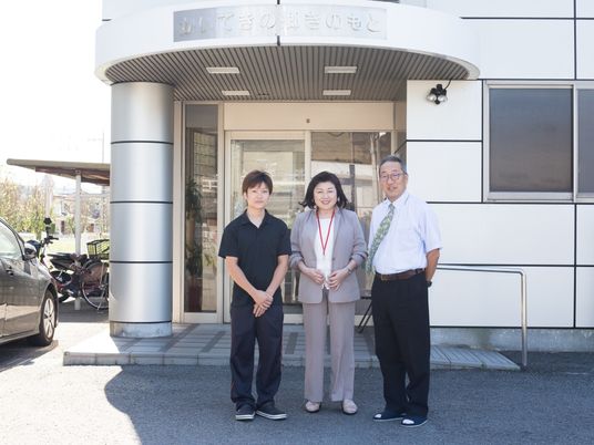 スタッフ立つ施設入口