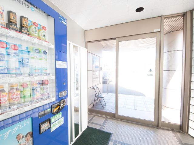 入口付近の自動販売機 玄関 充実した待合スペースを備えた明るいエントランスです。リラックスしながら飲み物を選ぶことができます。