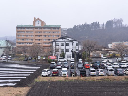 緑の山並みと施設の外観