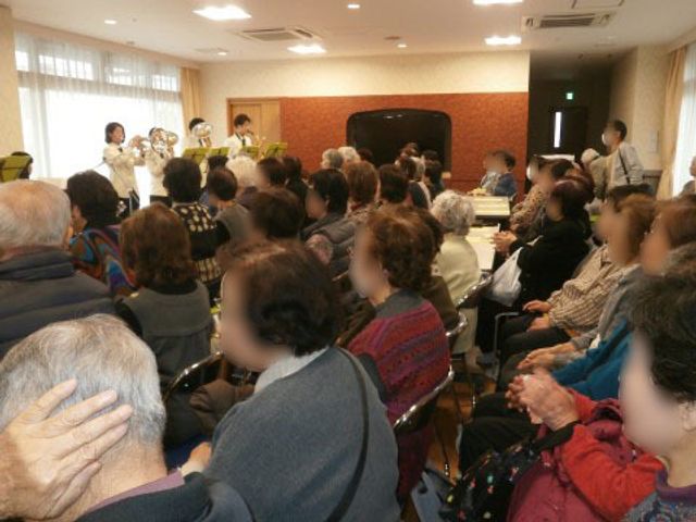 多目的室での音楽イベント イベント ゆったりとした椅子に座る利用者様が、前方で演奏される音楽を楽しんでいます。このような文化活動が可能な多目的室は、日々の生活に彩りを加えます。