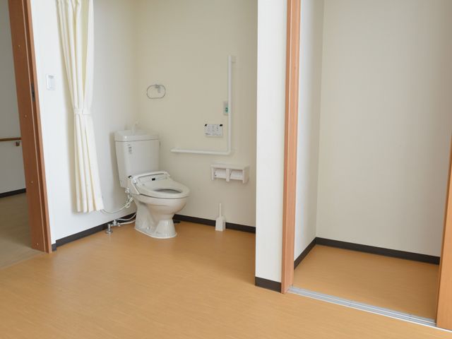 バリアフリー設計の洋室 居室内トイレ 手すりが設置された明るいトイレスペースです。安全かつ自立した日常生活をサポートする設計となっています。