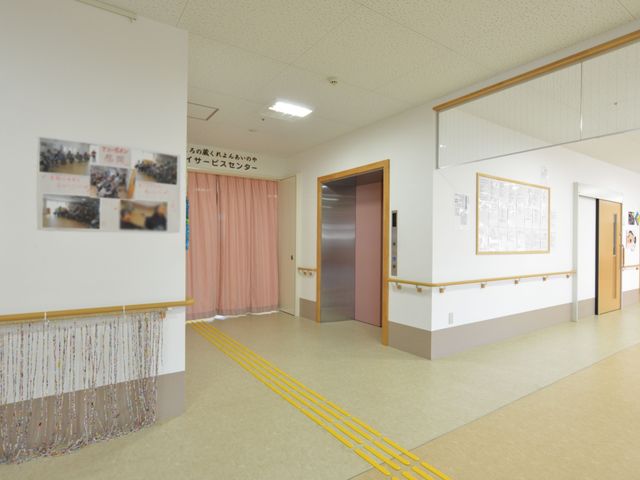 明るい廊下の風景 通路 手すりが整備された清潔感ある廊下は、スタッフと利用者の円滑な移動を支えています。お仕事を通じて安全で快適な生活空間を提供しませんか。