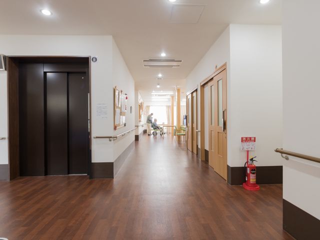 広々とした明るい廊下 通路 手すりが設置された温かみのある廊下です。ゆったりとしたスペースが就業環境の良さを感じさせます。
