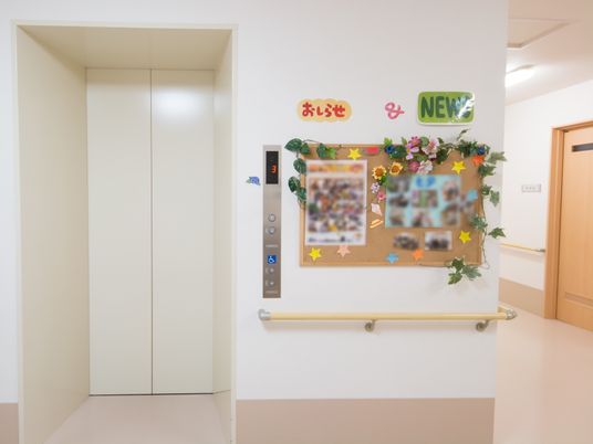 廊下のエレベーターと掲示板