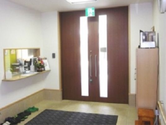 バリアフリーが施されている。入って右側に受付がある。中央には玄関マットが敷かれており、脇には踏み台が置かれている。