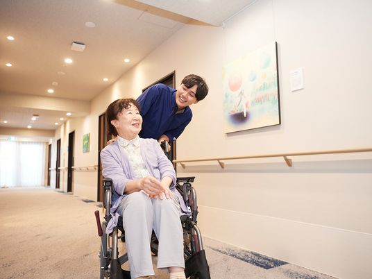 車椅子の方と介護者がいる廊下