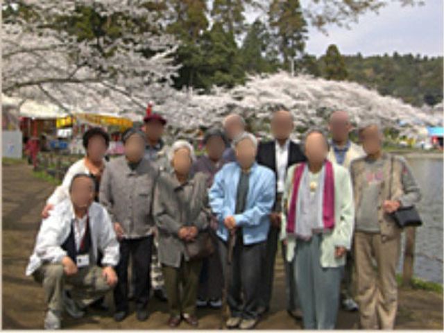 桜の下の集合 アクティビティ 桜並木が美しい中庭で、穏やかなひとときを共にしている方々の姿が見受けられます。四季折々の風景を楽しみながら、心地よい時間を過ごすことができます。