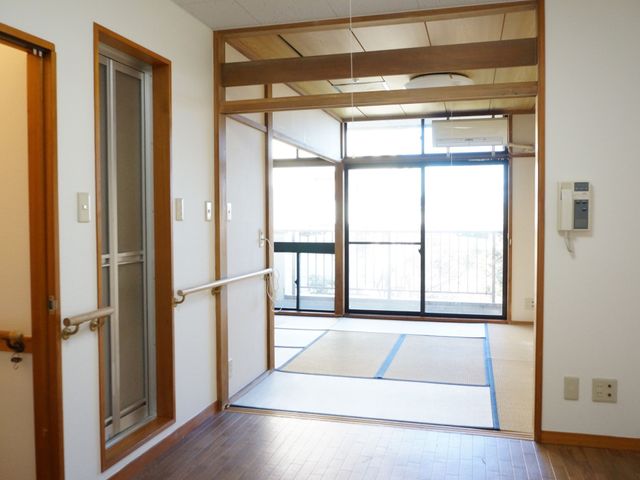明るい廊下と和室 居室 手すりが設置された廊下は、歩行に不安がある方も安心して移動できる設計になっています。和室への開放的な引き戸は、利用者のくつろぎや活動の場として最適です。