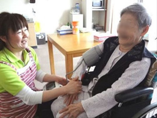 笑顔で手を握る介護職員