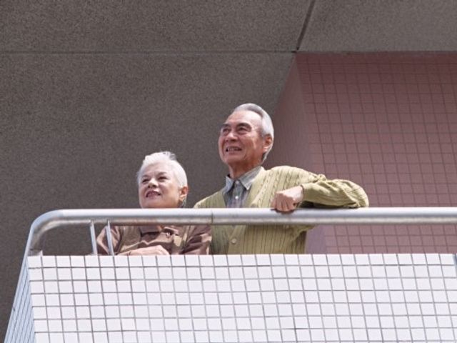 バルコニーでくつろぐ高齢者 入居者様 ゆったりとした空間のバルコニーでは、心地よい風を感じながらリラックスできます。身体を休めたり、新鮮な空気を取り入れながらのひと時をお過ごしいただけます。