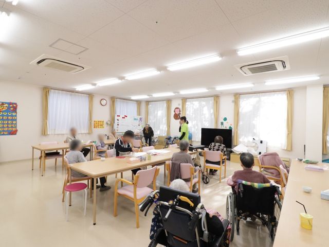 活動中の多目的室 デイサービス食堂 利用者が集い様々な活動をする暖かく明るい空間です。スタッフが手厚くサポートしながら日々の楽しみを提供しています。