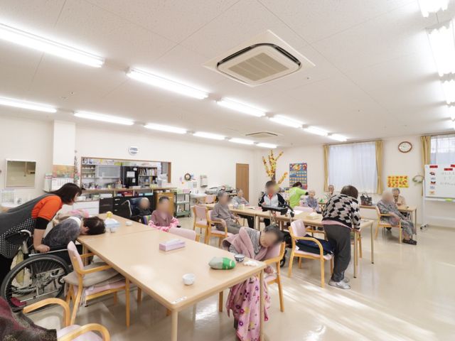 多目的スペースの様子 デイサービス食堂 ゆとりある設計の食堂で、明るい雰囲気の中、利用者がそれぞれの時間を過ごされています。スタッフの手厚いサポートもあり、心地よい交流の場となっています。