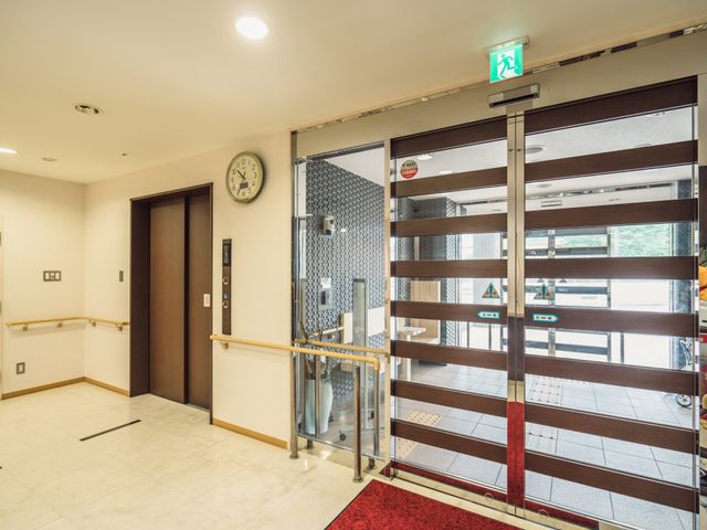 出入口とエレベーター 玄関 広々としたエントランスは、訪れる方を温かく迎えます。出入りしやすいガラスの扉や、待合に便利な椅子も整っています。