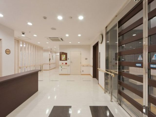清潔感のある廊下 エントランス 広々とした通路には手すりが設置され、安全面に配慮されています。明るく清潔な環境で、快適な勤務が見込めそうです。