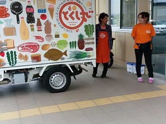 スタッフが車のそばに立つ外観  