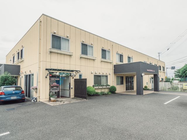 清潔な外観の建物 外観 ゆとりある駐車スペースのある建物です。入口には植物が飾られ、温かみを感じさせます。