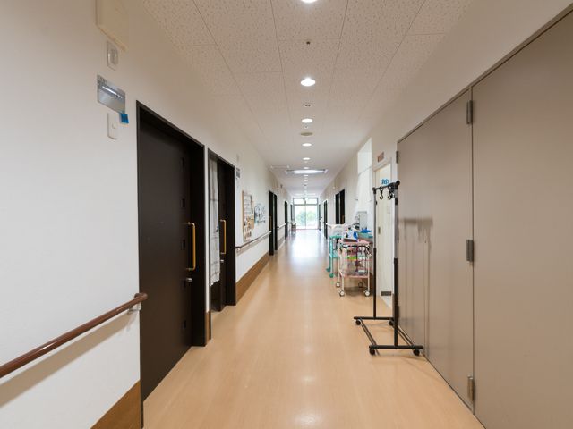 廊下の明るい光景 廊下 手すりが備えられた安心できる廊下です。壁に飾られたアートが温かい雰囲気を演出しており、快適な職場環境を提供しています。