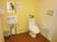 車椅子のままでも入れる広いスペースのトイレである。立ち座りのための手すりや、鏡と洗面台も付いている。