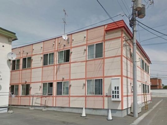 朱色のラインが特徴的な建物外観