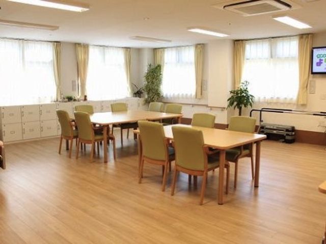 共有スペースの明るい居室 デイルーム 木の温もりを感じる清潔感のあふれる居室で、共に過ごせる環境が整っています。ゆったりとした座席が待ち構え、交流の場としてもぴったりです。