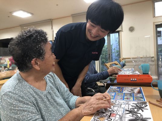 スタッフと遊ぶ笑顔の高齢者