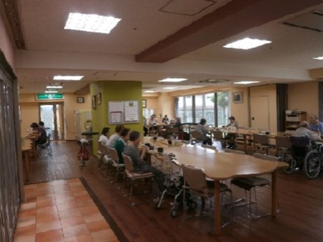 共有スペースでの憩いの風景 食堂 ゆったりとしたダイニングで、利用者の方々が食事や会話を楽しんでいる様子です。明るく開放的な雰囲気の中で、毎日の暮らしを支えるお手伝いができます。