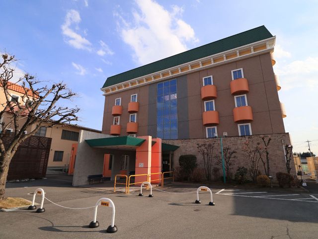 清潔感ある建物の外観 玄関前 ゆとりのある駐車スペースと、入り口にはバリアフリーの配慮が見受けられる、ゆったりとした建物です。