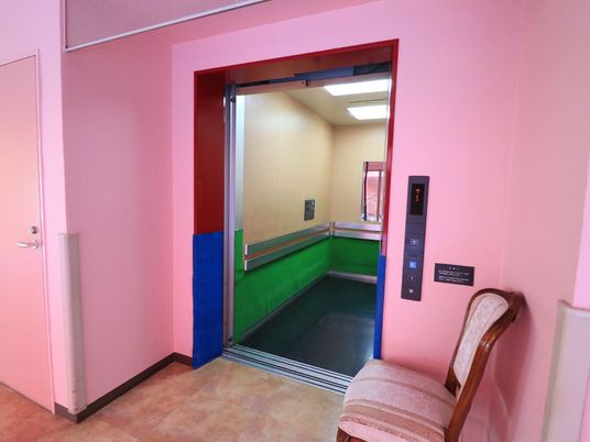 ピンク壁のエレベーター入口