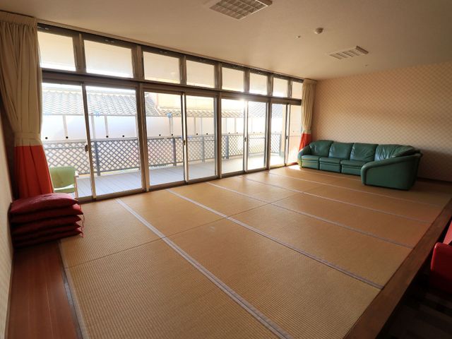 和室の居心地の良い空間 畳スペース ゆったりとした緑のソファがある明るい和室です。大きな窓からは光が差し込み、開放感を感じられる穏やかな時間を過ごせます。