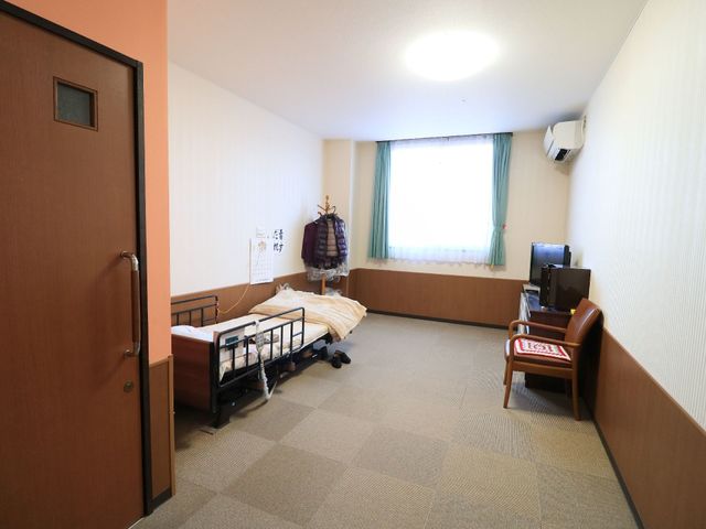 居室の端正な様子 居室 広々とした居室で、カーペットの色合いが落ち着いた雰囲気を醸し出しています。必要な家具が整い、清潔感もありますので、快適な生活空間となっております。