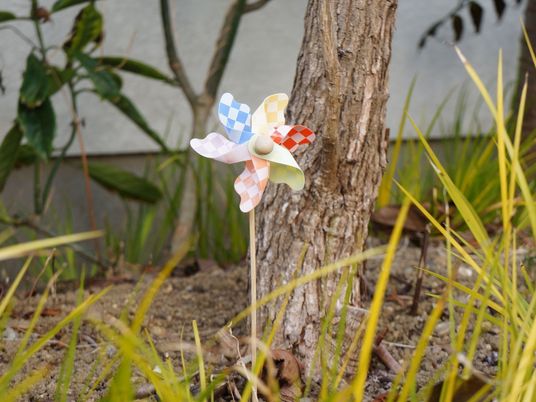 木に取り付けられたカラフルな風車