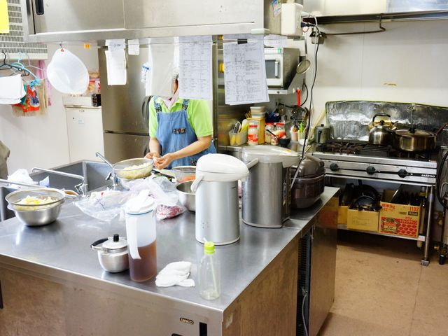 調理中のキッチン風景 キッチン 手際良く料理をするスタッフの姿が見えます。清潔で広々とした調理場は、働く環境としても理想的です。