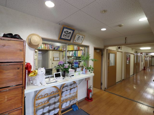 受付カウンターと廊下 玄関と受付 アットホームな雰囲気の受付スペースです。廊下にはプライバシーを守る個室の扉が並んでいます。