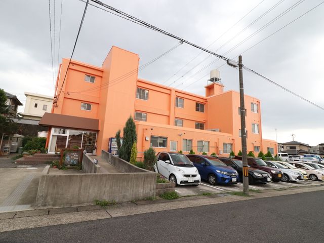 オレンジ色の建物外観 外観 オレンジ色が印象的な外観です。明るく開放感のある環境で、ここでの勤務は快適に感じられるかもしれません。