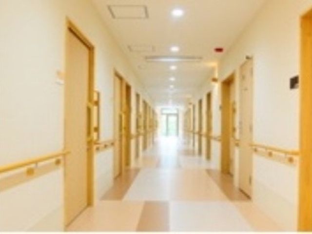 明るい廊下の風景 廊下2 ゆったりとした通路で、明るく清潔感があります。壁際に手すりが設置され、安心して歩ける環境が整っています。