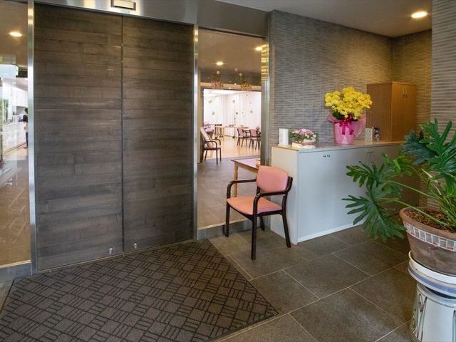 エントランスの様子 玄関 開放的なエントランスは来訪者を温かく迎えます。手入れの行き届いた鉢植えが優しい雰囲気を演出しています。