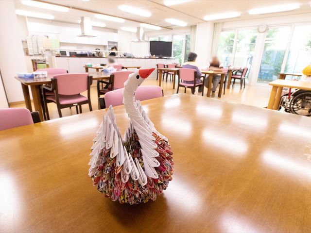 折り鶴飾りのあるダイニング 白鳥 ゆったりとしたスペースで、明るく開放的な食堂が備わっています。手作りの折り鶴が中心に飾られ、穏やかな時間を過ごせる空間です。