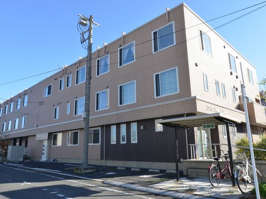 茶色の建物と自転車がある外観
