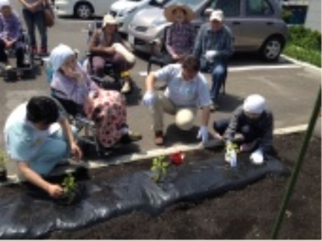 庭でのガーデニング活動 日常 利用者が一緒に植物の植え付けを行っている様子。お互いに協力しながら、屋外での活動を楽しんでいます。