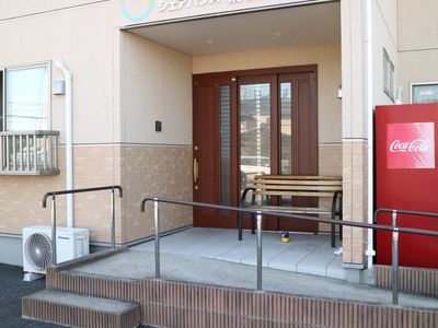 玄関とベンチのある外観