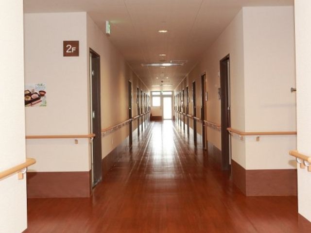 広々とした温もり廊下 廊下 明るく広々とした廊下は、移動がしやすく、快適な勤務環境を提供しています。手すりも整っており、安全に配慮された設計です。